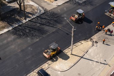 KYIV, UKRAINE - 10 Eylül 2020: Ağır asfalt yol silindirli ağır titreşimli paten sıkıştırıcısı, bir cadde üzerindeki yol inşaatında yeni bir sıcak asfalta baskı yapıyor..
