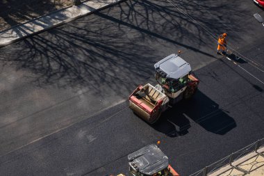 KYIV, UKRAINE - 10 Eylül 2020: Ağır asfalt yol silindirli ağır titreşimli paten sıkıştırıcısı, bir cadde üzerindeki yol inşaatında yeni bir sıcak asfalta baskı yapıyor..