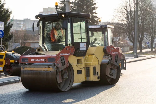 KYIV, UKRAINE - 10 Eylül 2020: Ağır asfalt yol silindirli ağır titreşimli paten sıkıştırıcısı, bir cadde üzerindeki yol inşaatında yeni bir sıcak asfalta baskı yapıyor..