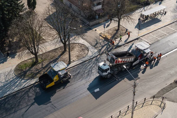KYIV, UKRAINE - 10 września 2020: Przemysłowe układarki asfaltowe układające świeży asfalt na budowie dróg na ulicy. — Zdjęcie stockowe