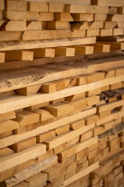 Bir kereste deposunda sıra sıra dizilmiş kereste tahtalarının yan görünümünü kapat.