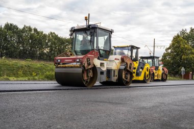 Yol yapımı sırasında yeni asfalt üzerinde çalışan ağır yol paten makinesi. Endüstri, ulaşım, makine, mühendislik, kentsel gelişim ve onarım kavramı.