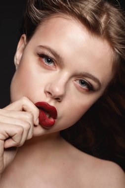 Studio moda portre siyah zemin üzerine kırmızı dudakları dokunmadan kadar karanlık yapmak ile genç esmer kız.