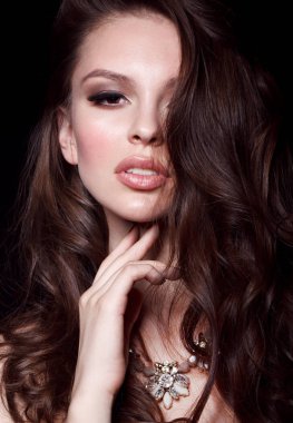 Güzel genç kadın modeli ile yüzünü el ile dokunmak kolye