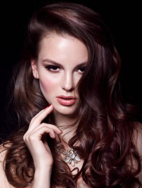 Güzel genç kadın modeli ile yüzünü el ile dokunmak kolye