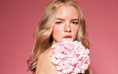 Çiçek ile model. Mükemmel makyaj. Güzellik. Pembe bir arka plan.