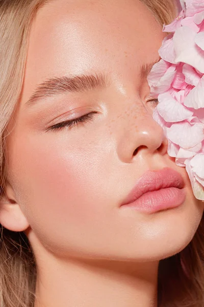 güzel sarışın model çıplak makyaj ve pembe çiçekler, yakın çekim