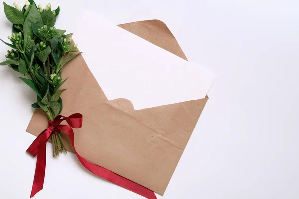 Craft paper envelope with white card.