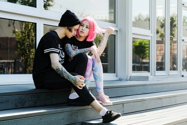 İki aşık. Güzel genç çift açık poz. Pembe saçlı kız ve yenilikçi