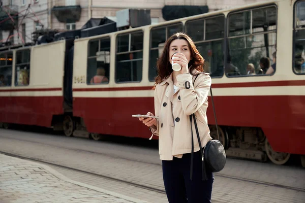 Ganska Ung Kvinna Dricka Avhämtning Kaffekopp Använder Smarta Telefonen Medan — Stockfoto