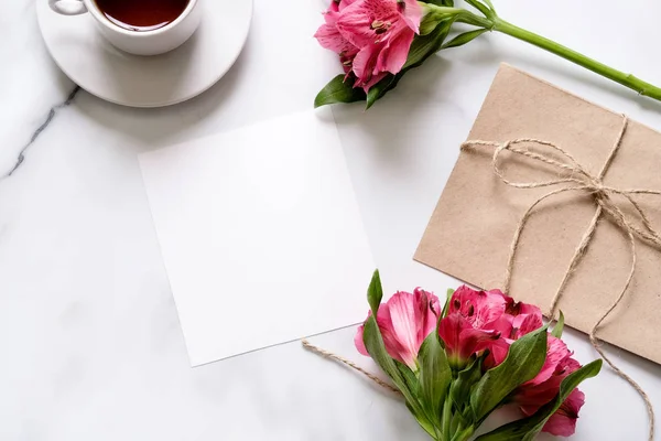 Escritorio Mármol Con Taza Café Flores Rosadas Postal Sobre Kraft — Foto de Stock