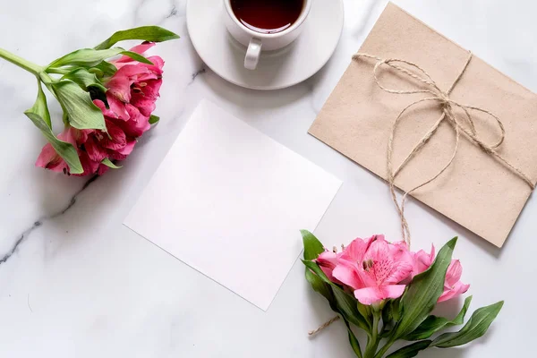 Escritorio Mármol Con Taza Café Flores Rosadas Postal Sobre Kraft — Foto de Stock