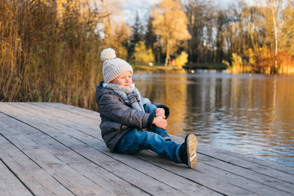 Симпатичный стильный мальчик у воды в осеннем парке
.