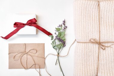 Zanaat zarf, hediye kutusu fiyonklu, örme şal, kurutulmuş çiçekler ve beyaz arka plan üzerinde bırakır. Kış, tatil kavramı. Düz yatıyordu, en iyi görünüm, kopya alanı