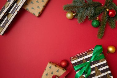 Noel tatil kompozisyon kopya alanı metniniz için kırmızı zemin üzerine. Top köşedeki, hediye kutusu ile Xmas ağacı çam dalları. Tebrik kartı için Xmas zemin. Düz yatıyordu, en iyi görünüm, ek yükü
