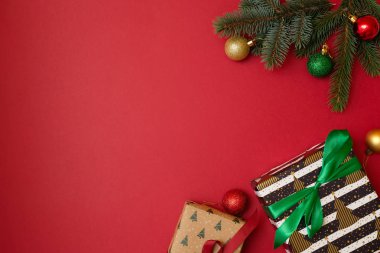 Noel tatil kompozisyon kopya alanı metniniz için kırmızı zemin üzerine. Top köşedeki, hediye kutusu ile Xmas ağacı çam dalları. Tebrik kartı için Xmas zemin. Düz yatıyordu, en iyi görünüm, ek yükü