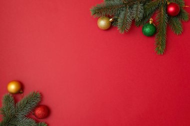 Noel tatil kompozisyon kopya alanı metniniz için kırmızı zemin üzerine. Xmas ağacı çam dalları ile topları köşelerinde, Xmas zemin tebrik kartı için. Düz yatıyordu, en iyi görünüm, ek yükü