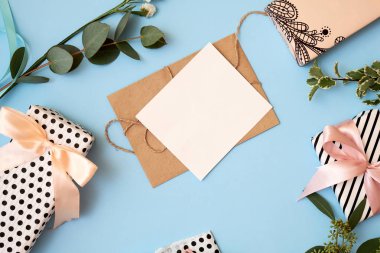 Çiçek yaprakları, hediye kutusu, zanaat zarf, kopya alanı metin için mavi zemin üzerine boş tebrik kartı. Mockup afiş için. Kadının gün 8 Mart, düğün, dating, aşk kavramı. Düz yatıyordu, en iyi görünümü