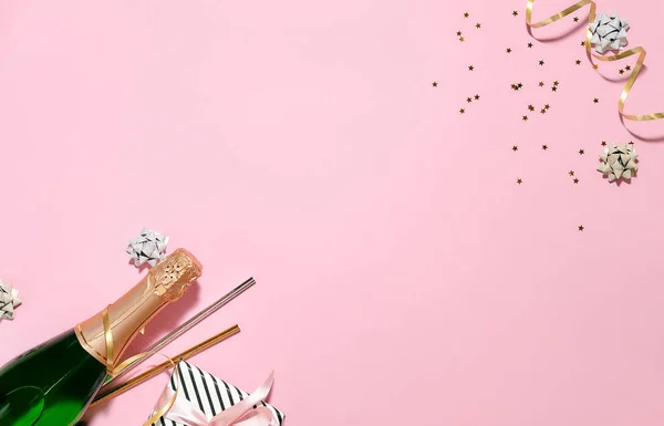 Champagnefles Met Kleurrijke Partij Slingers Geschenkdoos Met Lint Roze Achtergrond — Stockfoto