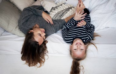 Aile evde eğleniyor. Mutlu genç anne ile çocuk yatak odasında oynarken.