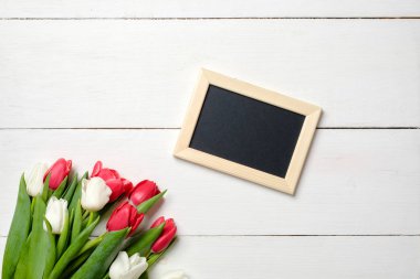 Beyaz tahta masaya Lale çiçek ile boş tebrik kartı. Romantik düğün kartı, kadının ya da anneler günü, doğum günü, Bahar tatili için tebrik kartı