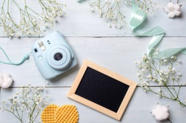 Fotoğraf makinesi, resim çerçevesi, tanımlama bilgileri ile kadın Danışma. En az çiçekli çerçeve, pastel renkler Bahar, düz stil, üstten görünüm yatıyordu. Güzellik teknoloji kavramı, moda blogger fotoğraf aygıt.