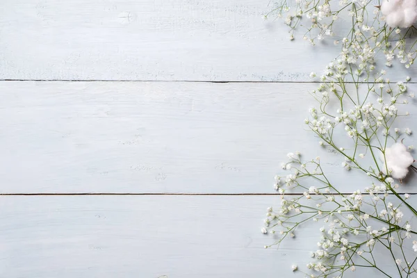 Spring background. White rustic flowers on blue wooden table. Banner mockup for womans or mother day, happy easter, spring holidays. Backdrop with copy space