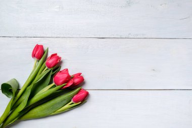 demet kırmızı lale mavi ahşap masa üzerinde. Kopya alanı ile mockup kart kutlama, kadın ya da anne gün, Paskalya, Bahar tatili, doğum günü için banner