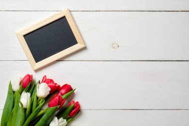 Beyaz tahta masaya Lale çiçek ile boş tebrik kartı. Romantik düğün kartı, kadının ya da anneler günü, doğum günü, Bahar tatili için tebrik kartı