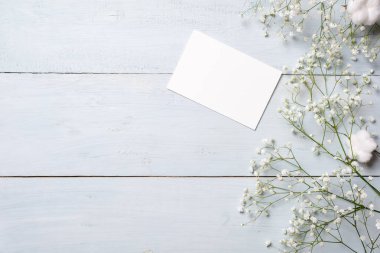 Gypsophila çiçek ışık mavi ahşap masa üzerinde daveti veya kutlama, küçük hediye kutusu, grup için boş kart. Kadının ya da anne günü, düğün invintation, Paskalya kartı için afiş mockup.
