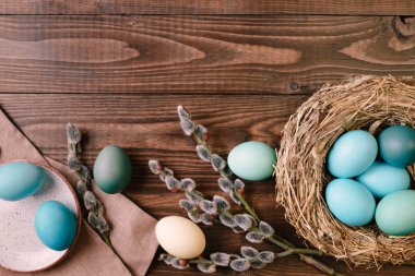 Turkuaz Paskalya yumurtaları ve ahşap masa üzerinde Kukum şube ile kuş yuvası. Görünümünün üzerinde düz yatıyordu Paskalya kompozisyon