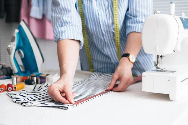 在裁缝店工作的年轻女子测量胶带 — 图库照片