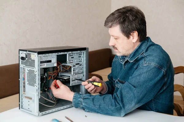 彼の手でドライバーを持つコンピューター技術者エンジニアはパーソナル コンピューターを修復しています コンピューターのハードウェア アップグレード テクノロジーの概念 — ストック写真
