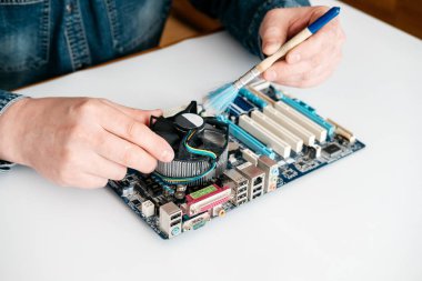 Technician using brush for computer cleaning, clean the motherboard from dust clipart