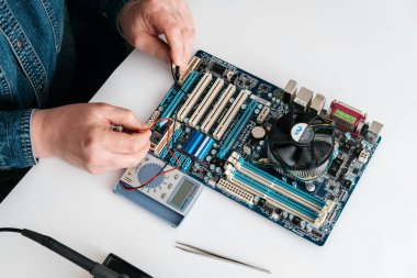 Bilgisayar anakart voltaj ölçümü için gerilim ölçer kullanarak echnician. Bilgisayar donanım, onarım, yükseltme ve teknoloji kavramı