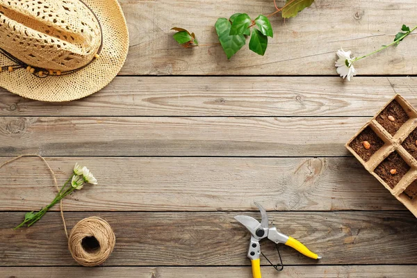 Πλαίσιο εργαλεία κηπουρικής και λουλούδια σε vintage ξύλινο τραπέζι. Κηπουρική ή φύτευση έννοια. Εργάζονται στον κήπο την άνοιξη. Επίπεδη lay, κορυφαία θέα, γενικά — Φωτογραφία Αρχείου