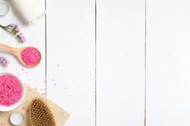 Doğal Cilt Bakımı ve spa kozmetik ürünleri en iyi görünümünü düz beyaz ahşap masa üzerinde yatıyordu. Çerçeve deniz banyosu tuzu, Masaj fırça, bambu ve çiçek. Güzellik düz yatıyordu kavramı