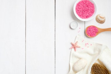 Pembe banyo tuzu, tahta kaşık, havlu, sabun denizyıldızı, bir kase spa fırça ahşap yüzey üzerinde. Spa yordamı konseptiyle banyo tuzu, düz yatıyordu, en iyi görünüm, ek yükü