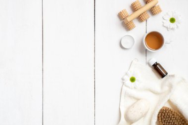 Bir fincan bitki çayı, havlu, sabun, uçucu yağ ve masseger beyaz tahta masada. Güzellik salonları, ek yükü sağlık kavramı, düz yatıyordu, en iyi görünüm için afiş mockup.