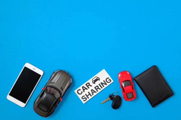 Car sharing concept. Composition with driver's license, vehicle key, toy cars, text sign 