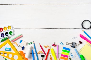 Okul konseptine geri dönelim, boş beyaz ahşap masa üzerinde çizim çocuklar öğretmek için renkli kırtasiye malzemeleri sınır çerçevesi. Yaratıcı eğitim ayarı, çocuk masası üst görünümü, düz döşeme, kopyalama alanı