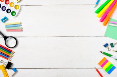 Okul konseptine geri dönelim, boş beyaz ahşap masa üzerinde çizim çocuklar öğretmek için renkli kırtasiye malzemeleri sınır çerçevesi. Yaratıcı eğitim ayarı, çocuk masası üst görünümü.