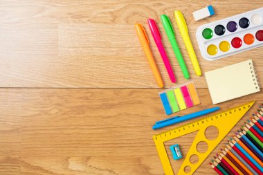 Ahşap masa üzerinde okul malzemeleri, eğitim, eğitim ve geri okul kavramı. Çocuk masası üst görünümü, kopyalama alanı, düz döşeme kompozisyonu.