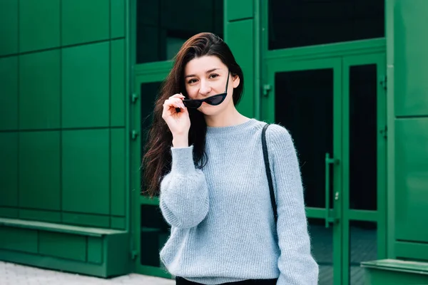 Utomhus porträtt av vacker ung brunett flicka. Teenage glamour girl med solglasögon bär trendiga outfit poserar i City Street. Urban Style Concept, grön bakgrund — Stockfoto