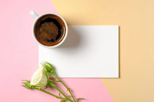 Пустая бумажная карточка с копировальным пространством, чашкой кофе и цветами белых роз на красочном фоне. Понятие любви, нежности, утреннего завтрака, свиданий, свежести. Стол для блогеров красоты. Минимальный дизайн . — стоковое фото