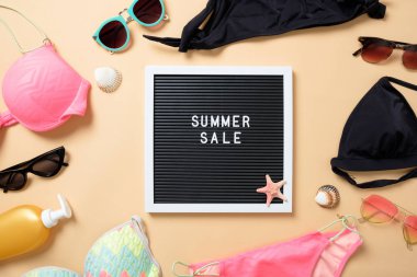 Kadın plaj aksesuarları: güneş gözlükleri, mayolar ve sarı arka planda 