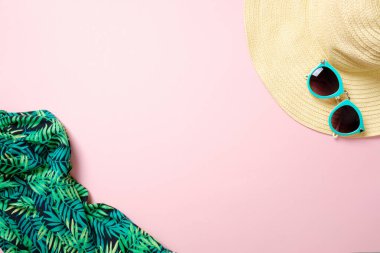 Hasır şapka, güneş gözlüğü, metin için kopya alanı ile pastel pembe arka plan üzerinde eşarp. Yaz kadın moda kıyafeti, plaj şeyler, tatil aksesuarları. Üst görünüm seyahat veya tatil konsepti, düz döşeme seti