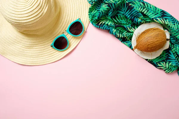 Женские пляжные аксессуары: соломенная шляпа, солнцезащитные очки, кокос, зеленый шарф на розовом фоне. Концепция путешествий, летний фон с копировальным пространством. Плоская кладка, вид сверху, навес . — стоковое фото