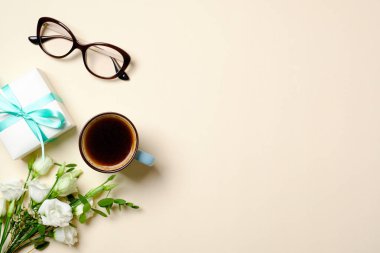 Kahve fincanı, hediye kutusu, gözlük, gül çiçek buket, kurdele ve kadınsı moda aksesuarları ile Düz yatıyordu kadın ev ofis masası. Üst görünüm kadın çalışma alanı, güzellik blogger kız masaüstü, kopya alanı.