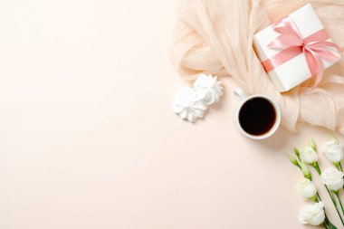 Düz yatıyordu ev ofis masası. Atkı, kahve fincanı, hediye kutusu, marshmallow ve pembe arka plan üzerinde gül çiçekleri ile Kadın çalışma alanı. Metin için kopyalama alanı ile üst görünüm kadınsı arka plan.